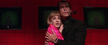 Movie still from “Mars Attacks!” (1996), directed by Tim Burton – A man and a woman are posing for a picture; Close Up shot, Low angle