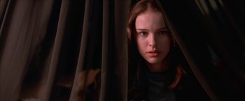 Movie still from “Mars Attacks!” (1996), directed by Tim Burton – A young girl is hiding behind a curtain; Close Up shot, Low angle