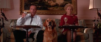 Movie still from “Mars Attacks!” (1996), directed by Tim Burton – Two people and a dog sitting on a couch; Medium shot, Low angle