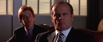 Movie still from “Mars Attacks!” (1996), directed by Tim Burton – A man in a suit and tie looking at the camera with another man behind him; Close Up shot, Over the shoulder angle