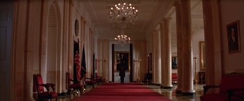 Movie still from “Mars Attacks!” (1996), directed by Tim Burton – A person walking down a hall way in a building; Extreme Wide shot, Low angle
