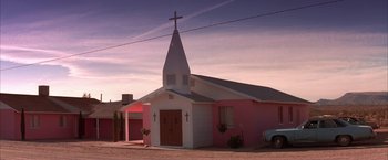 Movie still from “Mars Attacks!” (1996), directed by Tim Burton – A pink and white church with a cross on the top; Extreme Wide shot, Low angle