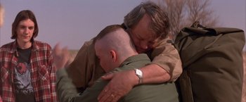 Movie still from “Mars Attacks!” (1996), directed by Tim Burton – A man hugging another man with a watch on his wrist; Close Up shot, Over the shoulder angle
