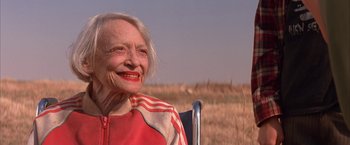 Movie still from “Mars Attacks!” (1996), directed by Tim Burton – An older woman sitting in a chair in a grassy field; Close Up shot, Low angle