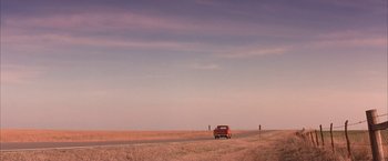 Movie still from “Mars Attacks!” (1996), directed by Tim Burton – An old red truck driving down a road; Extreme Wide shot, Low angle