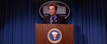 Movie still from “Mars Attacks!” (1996), directed by Tim Burton – A man standing at a podium in front of the white house; Medium shot, Low angle