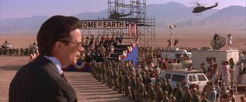 Movie still from “Mars Attacks!” (1996), directed by Tim Burton – A group of men in uniform marching down a street; Extreme Wide shot, High angle