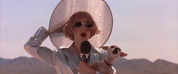 Movie still from “Mars Attacks!” (1996), directed by Tim Burton – A woman holding a microphone and a small dog; Close Up shot, Low angle