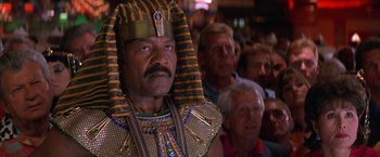 Movie still from “Mars Attacks!” (1996), directed by Tim Burton – A man in a pharaoh's outfit standing in front of a group of people; Close Up shot, Low angle