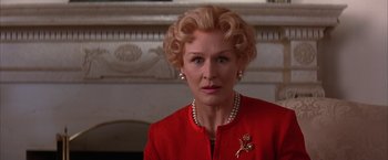 Movie still from “Mars Attacks!” (1996), directed by Tim Burton – An older woman in a red dress with a rose pin; Close Up shot, Low angle