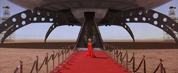 Movie still from “Mars Attacks!” (1996), directed by Tim Burton – A woman in a red dress standing on a red carpet; Extreme Wide shot, High angle