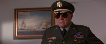 Movie still from “Mars Attacks!” (1996), directed by Tim Burton – An older man in a military uniform wearing sunglasses; Close Up shot, Low angle