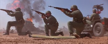 Movie still from “Mars Attacks!” (1996), directed by Tim Burton – Two men in military fatigues kneeling and holding guns; Wide shot, Low angle