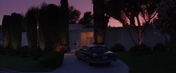 Movie still from “Mars Attacks!” (1996), directed by Tim Burton – A car parked in front of a house at night; Extreme Wide shot, Low angle