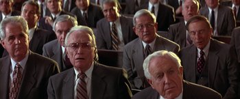 Movie still from “Mars Attacks!” (1996), directed by Tim Burton – A group of men in suits and ties sitting next to each other; Close Up shot, High angle