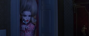 Movie still from “Mars Attacks!” (1996), directed by Tim Burton – A woman with a strange hair style standing next to a door; Close Up shot, Over the shoulder angle
