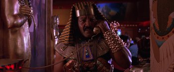 Movie still from “Mars Attacks!” (1996), directed by Tim Burton – A man in a costume talking on a phone; Close Up shot, Low angle