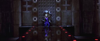 Movie still from “Mars Attacks!” (1996), directed by Tim Burton – A woman in a purple dress standing in front of a wall; Wide shot, Low angle