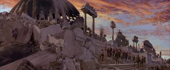 Movie still from “Mars Attacks!” (1996), directed by Tim Burton – A group of people standing on top of a pile of rubble; Extreme Wide shot, High angle