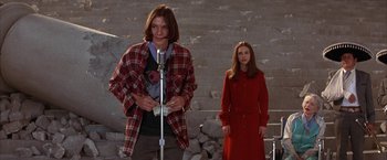 Movie still from “Mars Attacks!” (1996), directed by Tim Burton – A man and a woman standing next to each other in front of a brick wall; Medium shot, Low angle