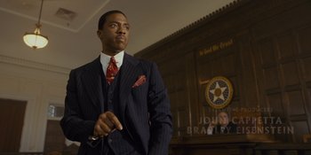 Movie still from “Marshall” (2017), directed by Reginald Hudlin – A man in a suit standing in front of a wall; Medium shot, Low angle