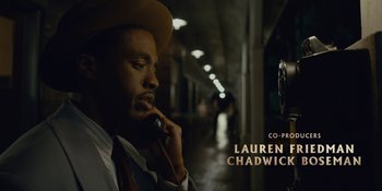 Movie still from “Marshall” (2017), directed by Reginald Hudlin – A man in a hat and a tie talking on a phone; Close Up shot, High angle