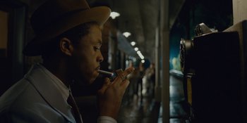 Movie still from “Marshall” (2017), directed by Reginald Hudlin – A man smoking a cigarette while wearing a hat; Close Up shot, Over the shoulder angle