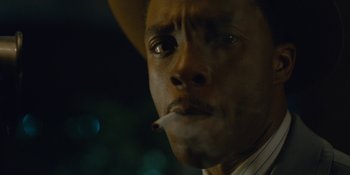 Movie still from “Marshall” (2017), directed by Reginald Hudlin – A person with a hat smoking a cigarette; Extreme Close Up shot, Low angle