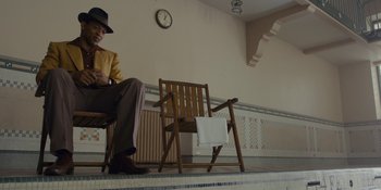 Movie still from “Marshall” (2017), directed by Reginald Hudlin – An older man sitting on a chair next to an empty chair; Wide shot, Low angle