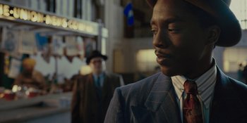 Movie still from “Marshall” (2017), directed by Reginald Hudlin – A man wearing a suit and tie standing next to another man wearing a suit and tie; Close Up shot, Over the shoulder angle
