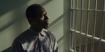 Movie still from “Marshall” (2017), directed by Reginald Hudlin – A man looking out of a window in a room; Close Up shot, High angle