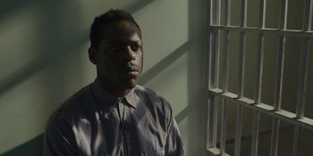 Movie still from “Marshall” (2017), directed by Reginald Hudlin – A man standing in front of a window with bars; Close Up shot, High angle