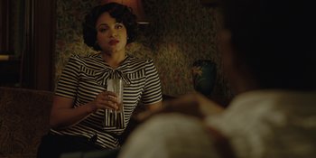 Movie still from “Marshall” (2017), directed by Reginald Hudlin – A woman sitting on a chair holding a drink; Medium shot, Over the shoulder angle