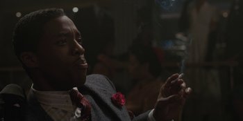 Movie still from “Marshall” (2017), directed by Reginald Hudlin – A man in a suit and tie smoking a cigarette; Close Up shot, Over the shoulder angle