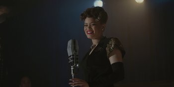 Movie still from “Marshall” (2017), directed by Reginald Hudlin – A woman in a black dress is holding a microphone; Medium shot, Low angle