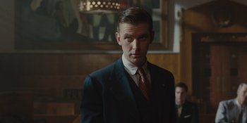 Movie still from “Marshall” (2017), directed by Reginald Hudlin – A man wearing a suit and tie in a room; Medium shot, Low angle