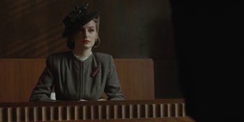 Movie still from “Marshall” (2017), directed by Reginald Hudlin – A woman wearing a hat sitting in a courtroom; Medium shot, Over the shoulder angle