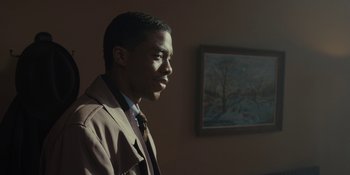 Movie still from “Marshall” (2017), directed by Reginald Hudlin – A man in a brown jacket standing in front of a painting; Close Up shot, Over the shoulder angle