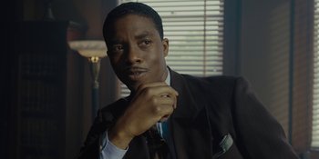 Movie still from “Marshall” (2017), directed by Reginald Hudlin – A man in a suit and tie putting on a tie; Close Up shot, Low angle