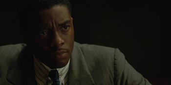 Movie still from “Marshall” (2017), directed by Reginald Hudlin – A person wearing a suit and tie; Close Up shot, Over the shoulder angle