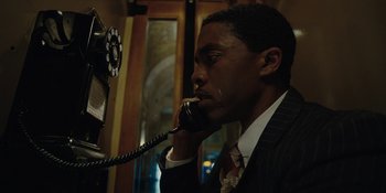 Movie still from “Marshall” (2017), directed by Reginald Hudlin – A man talking on a phone while wearing a suit and tie; Close Up shot, Low angle