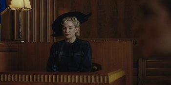 Movie still from “Marshall” (2017), directed by Reginald Hudlin – A woman sitting in front of a wooden table; Medium shot, Low angle