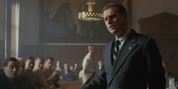 Movie still from “Marshall” (2017), directed by Reginald Hudlin – A man in a suit and tie in a courtroom; Medium shot, Low angle