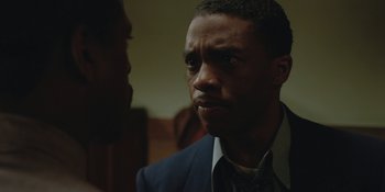 Movie still from “Marshall” (2017), directed by Reginald Hudlin – A man in a suit and tie looking at a camera; Close Up shot, Over the shoulder angle
