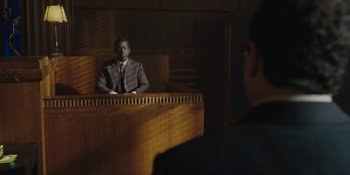 Movie still from “Marshall” (2017), directed by Reginald Hudlin – A man sitting in front of a judge in a courtroom; Medium shot, Over the shoulder angle