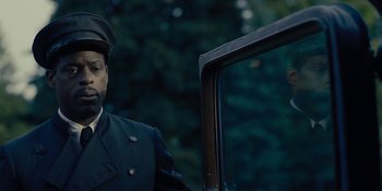 Movie still from “Marshall” (2017), directed by Reginald Hudlin – A man wearing a hat standing in front of a car; Close Up shot, Low angle
