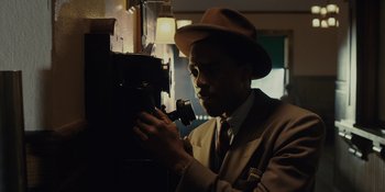 Movie still from “Marshall” (2017), directed by Reginald Hudlin – A man wearing a suit and a hat looking at a camera; Close Up shot, Low angle