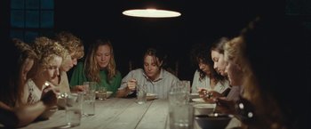 Movie still from “Martha Marcy May Marlene” (2011), directed by Sean Durkin – A group of people sitting at a dinner table; Medium shot, Low angle