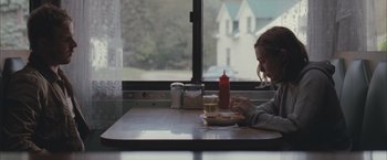 Movie still from “Martha Marcy May Marlene” (2011), directed by Sean Durkin – A woman sitting at a table with a plate of food; Medium shot, Over the shoulder angle