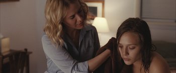 Movie still from “Martha Marcy May Marlene” (2011), directed by Sean Durkin – A woman is holding a towel over a woman's head; Close Up shot, Over the shoulder angle